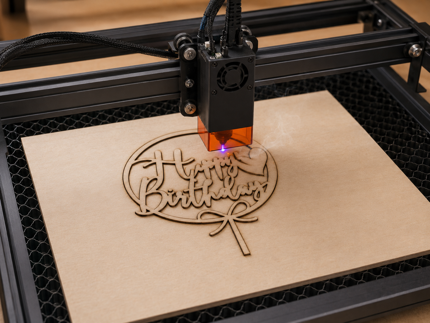 Laser izrezuje drveni topper za tortu s natpisom „Happy Birthday” iz šperploče.